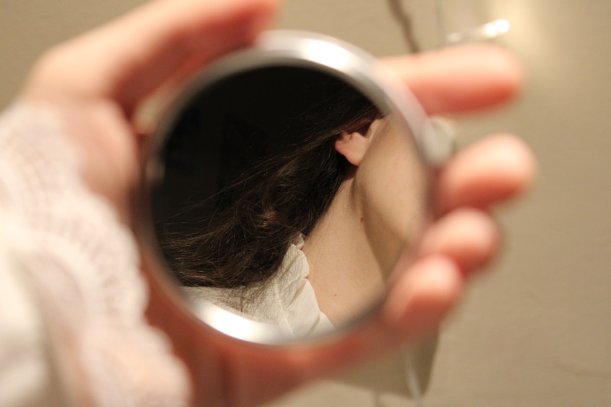 Photo by Karina Syrotiuk A person holding a mirror in their hand